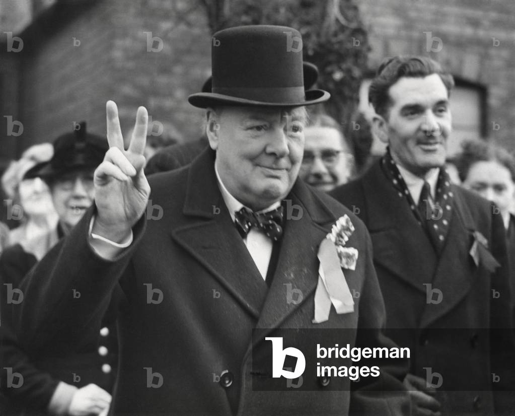 Conservative Party Leader Winston Churchill gives his familiar victory sign. He was making a last-minute campaign tour before the General Election. Woodford, Essex. Feb. 23, 1950.