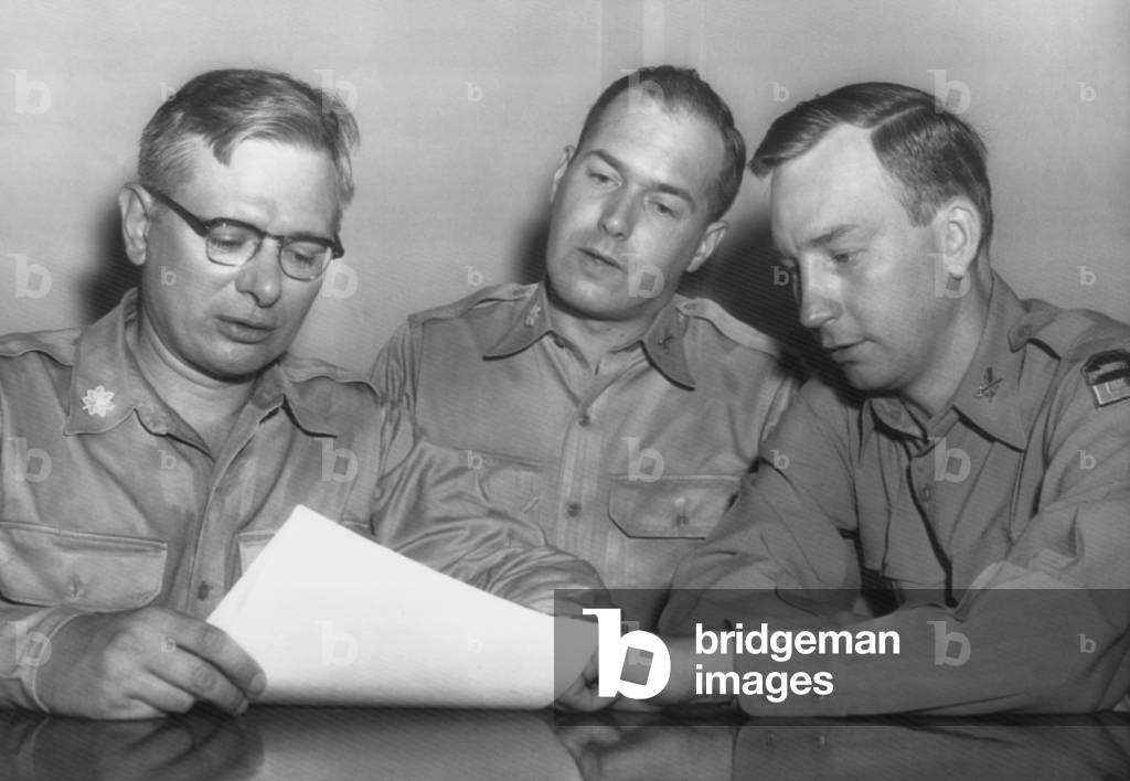 Major Roland E. Alley (center), a 14 year Army veteran, charged misconduct as a Korean War POW. August 22, 1955. His lawyer, Col. William T. Logan, warned that he was being singled out as a scapegoat while the Army was under pressure for being 'soft on Communism' by Joseph McCarthy. Convicted, he served 3.5 years in Leavenworth. In Sept. 1973, as a successful surveyor in Maine, he sought to have his case reviewed