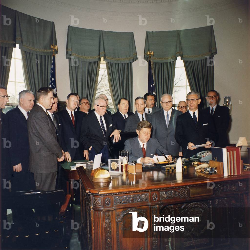 President Kennedy signing the Manpower Development and Training Act of 1962. Among the witnesses are Secretary of Labor Arthur Goldberg, Vice President Johnson, Labor Leader George Meany, and Rep. Adam Clayton Powell. March 15, 1962