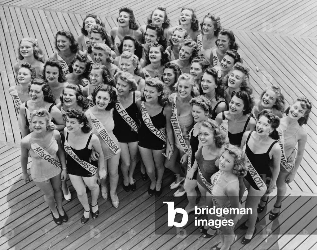 Miss America contestants huddle together on the Boardwalk in Atlantic City, New Jersey. 1941