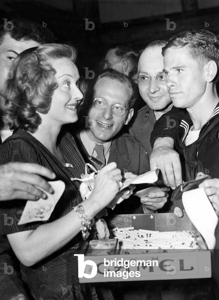 BETTE DAVIS hands out autographs and cigarettes to grateful servicemen at the Hollywood Canteen, 10/4/42