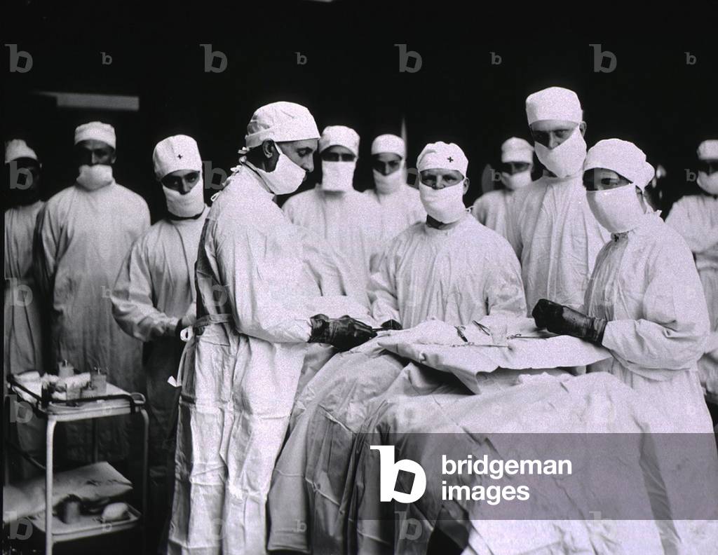 Surgeons and nurses masked in preparation for surgery at U.S. Army General Hospital in Detroit, Michigan. c. 1920