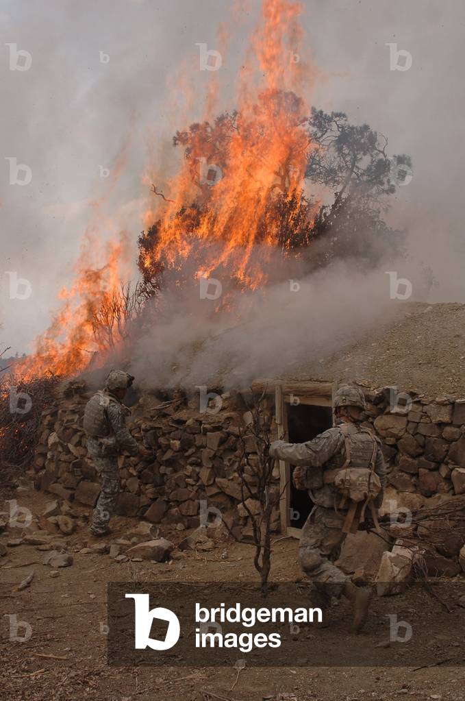 U.S. Army soldiers burn down a Taliban safe house discovered during operations in the Paktika province of Afghanistan. March 30 2007., Photo by:Everett Collection