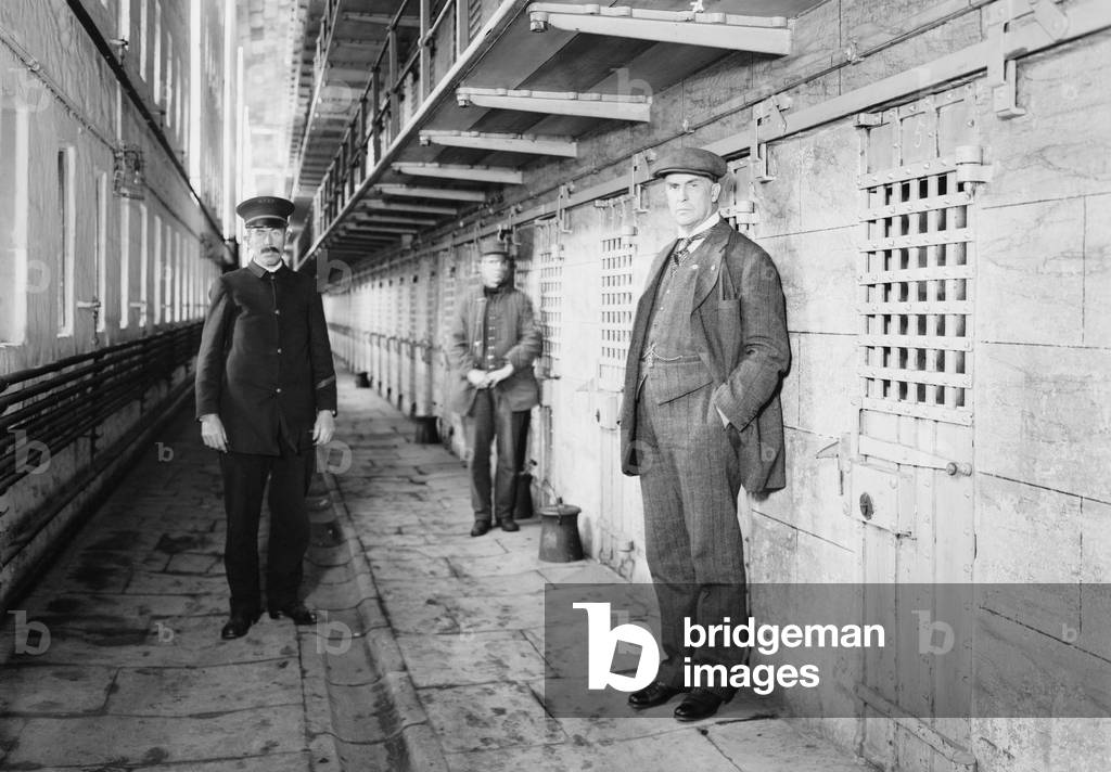 Thomas Mott Osborne (at right), Warden of Sing Sing prison in a cell block with guards. He instituted reform and rehabilitation programs at Sing Sing and later founded Mutual Welfare League, which helped discharged prisoners obtain employment. c. 1914