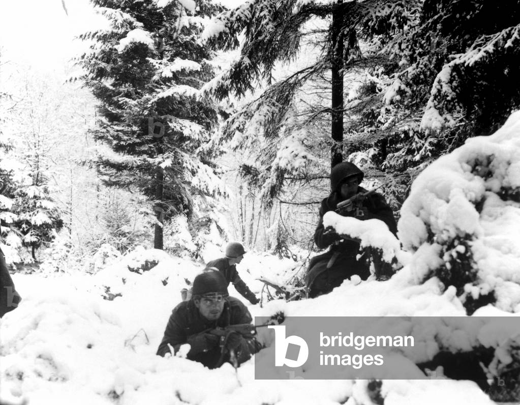 World War II. US Army infantrymen take cover in the snow in the Ardennes, Belgium. Dec 1944-January 1945