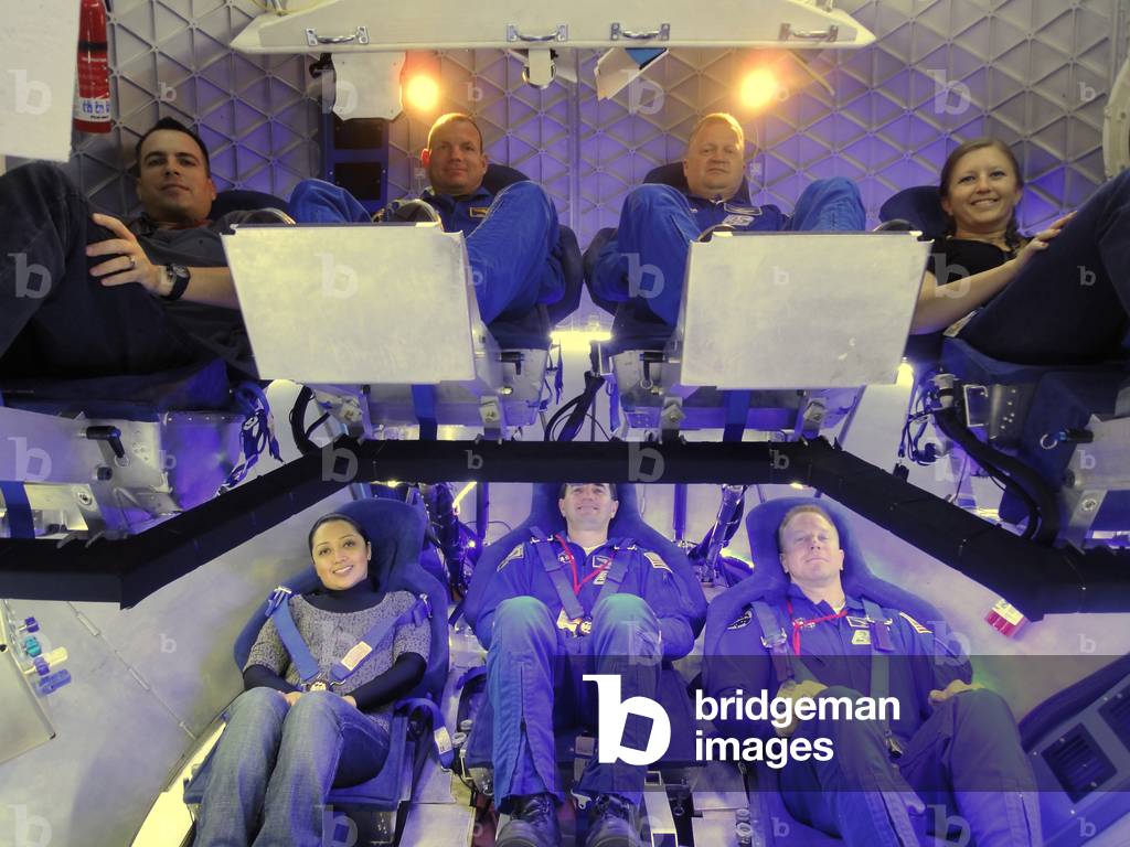 NASA astronauts and industry experts check out the crew accommodations in the Dragon spacecraft under development