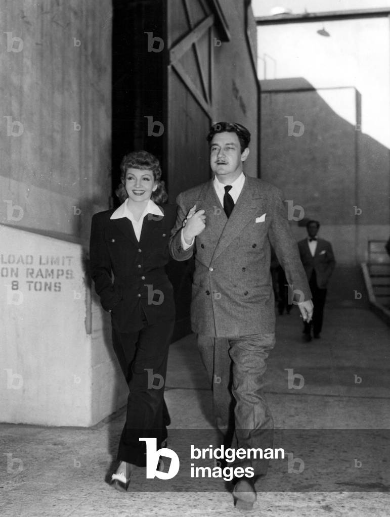 CLAUDETTE COLBERT and PRESTON STURGES stroll to the PALM BEACH STORY set, 1942