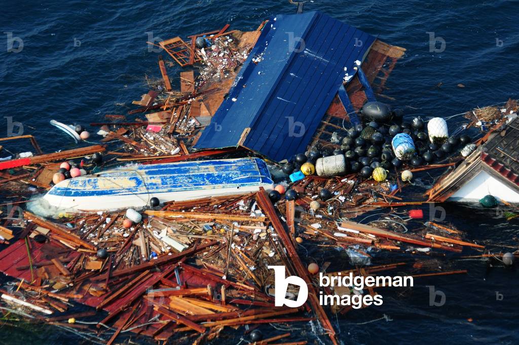 An overturned tug boat floats in the debris in left by the March 11 2011 tsunami Ofunato Japan. March 15 2011.,
