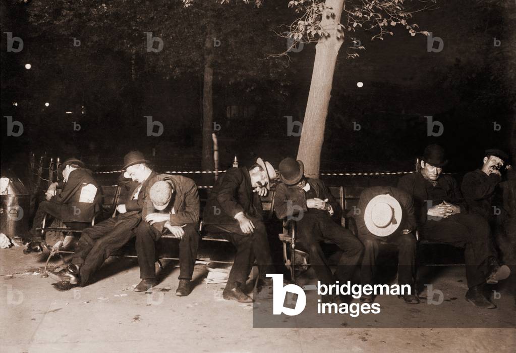 Homeless men sleeping on a park bench in New York City, 1910