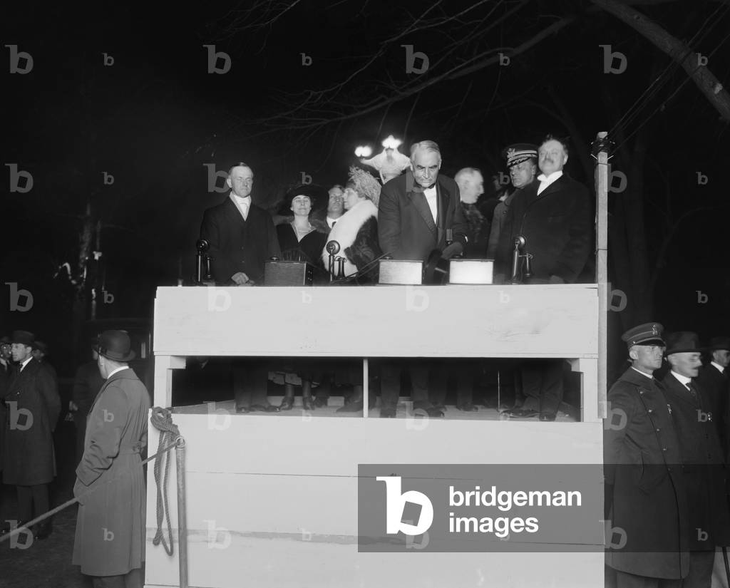 President Warren Harding pressing a ceremonial electric button. With him on the simple wooden podium is First Lady Florence Harding, Vice President Calvin and Grace Coolidge. c. 1921-22