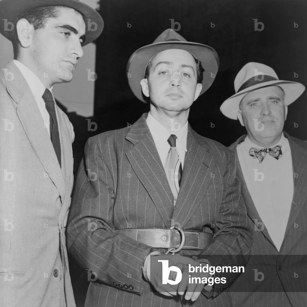 Harry Gold under arrest for spying in 1950. He confessed to espionage and helping Klaus Fuchs pass Manhattan Project secrets to the Soviets.