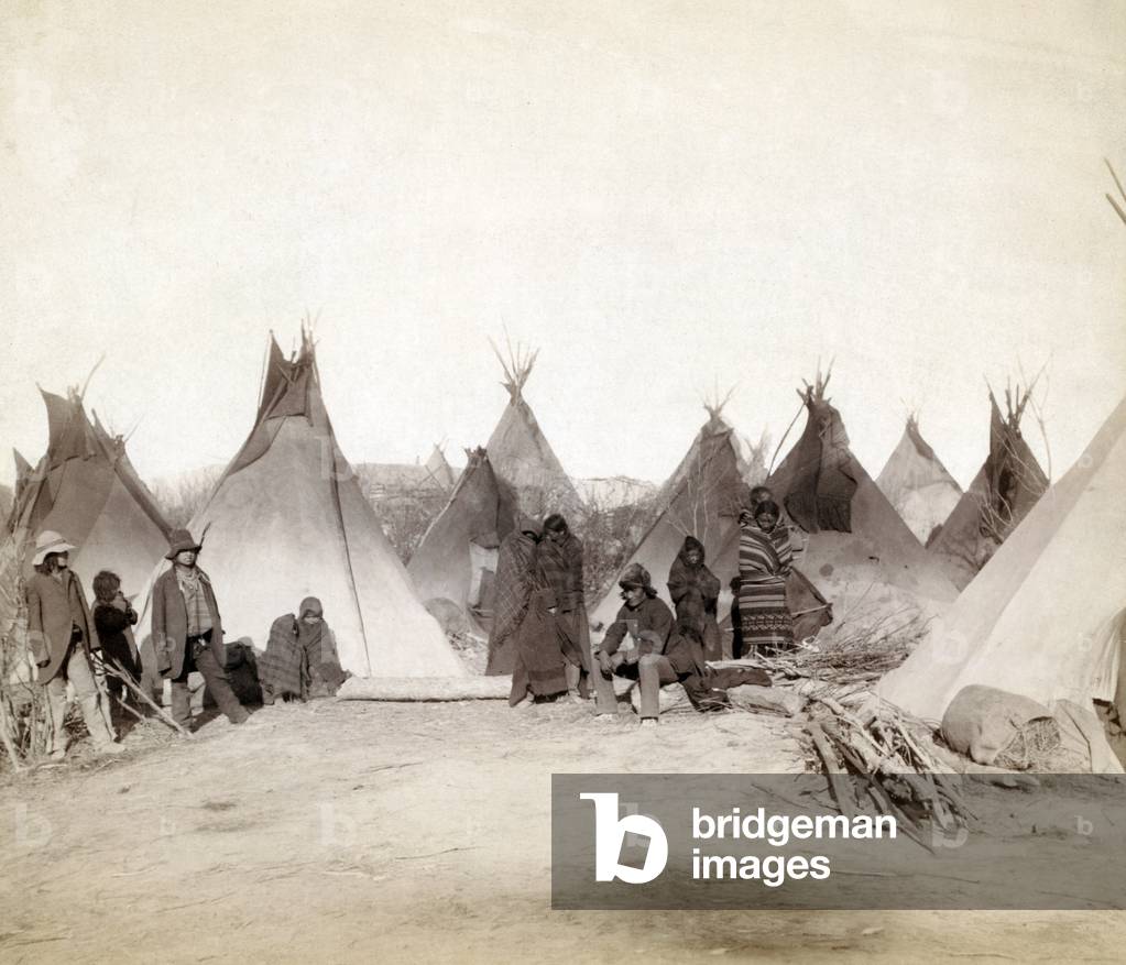 What's left of Big Foot's band. Miniconjou (children and adults)--many are looking away from camera--in a tepee camp, probably on or near Pine Ridge Reservation. Pine Ridge, South Dakota. Photo by John C. Grabill. 1891