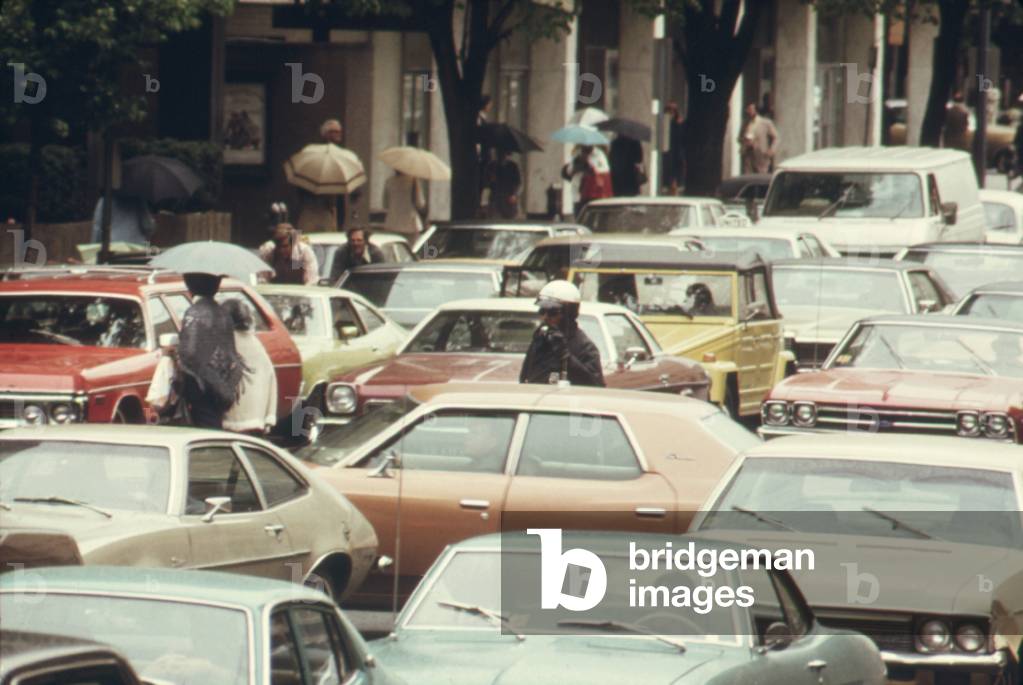 A Washington D.C. policeman stands among gridlocked cars during a bus strike leaving 250 000 to find alternate transportation to work. May 1974