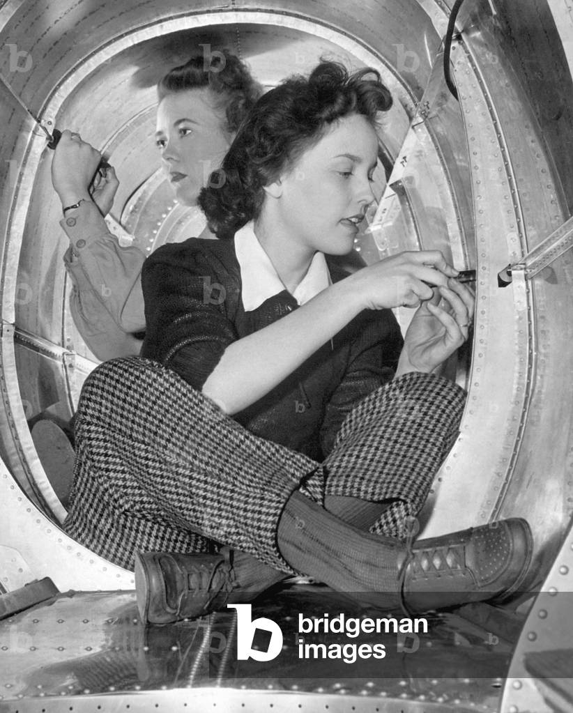 Two women workers in a cramped aircraft space at Grumman Aircraft Engineering Corp. During World War 2, c. 1942-45