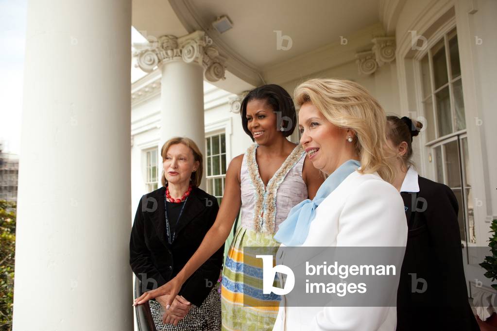 Michelle Obama hosts First Lady of Russia Svetlana Medvedeva on the Truman Balcony of the White House. Michelle wears a Tracy Feithdress with a bodice of hand dyed cotton and silk trimmed with strips of metallic shot and a tea dyed chiffon and cotton batik skirt.,
