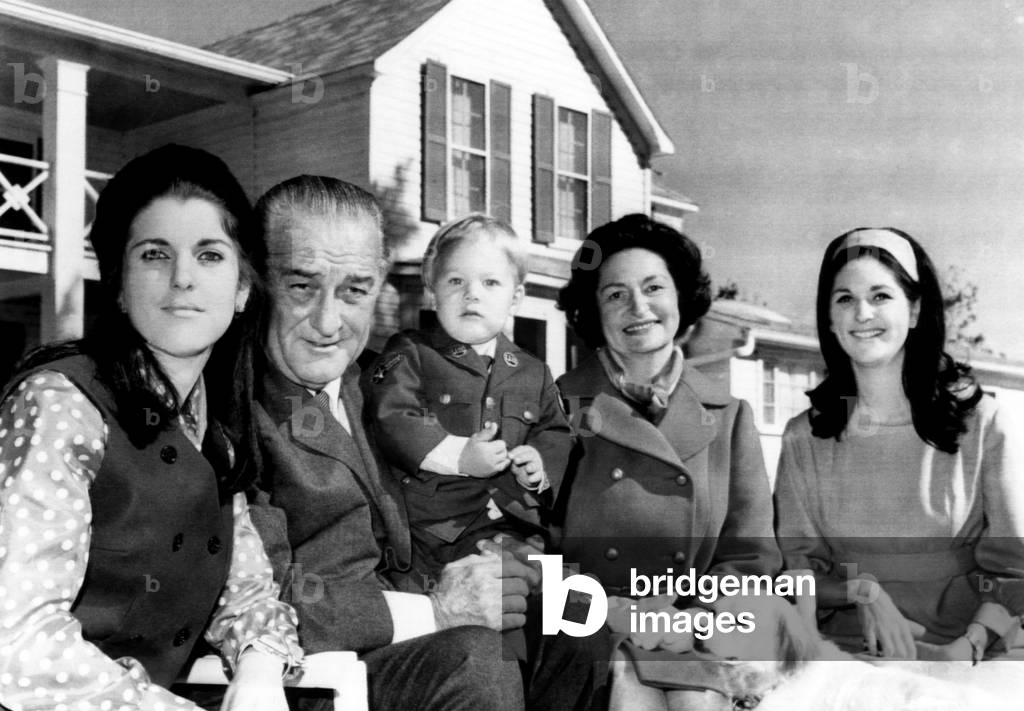 The first family pose for pictures on the front lawn of the LBJ Ranch shortly after attending Thanksgiving services in Fredericksburg, Texas. L to r: daughter Luci Nugent, President Johnson, grandson Lyn, wife Lady Bird, and daughter Lynda. November 28, 1968.