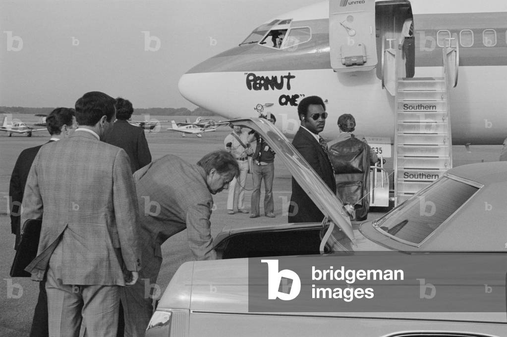 Jimmy Carter retrieving his luggage from a car before boarding 'Peanut One' campaign airplane. Carter appeared as a man of the people by carrying his own luggage when campaigning. Sept. 13, 1976
