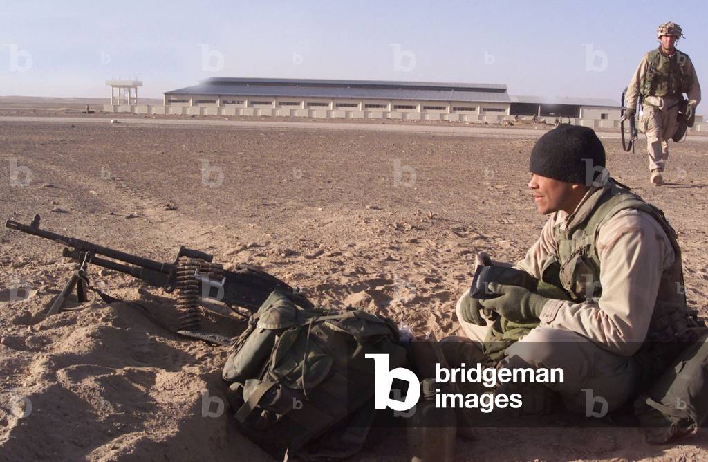 An Special Operations infantryman takes bite to eat while scanning the Afghan desert for enemy forces after the seizure of a forward operating base on Nov. 26 2001 as U.S. lead war against the ruling Taliban government begins., Photo by:Everett Collection