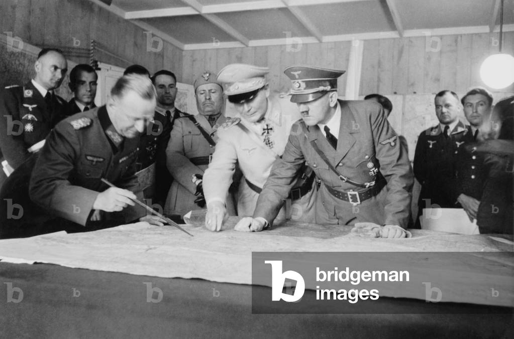 Adolf Hitler, Hermann Goering, and a German officer, looking at map. Behind then are Benito Mussolini and other German military officers, at Anlage Sud (Installation South) Strzyzow, Poland. Aug. 26, 1941