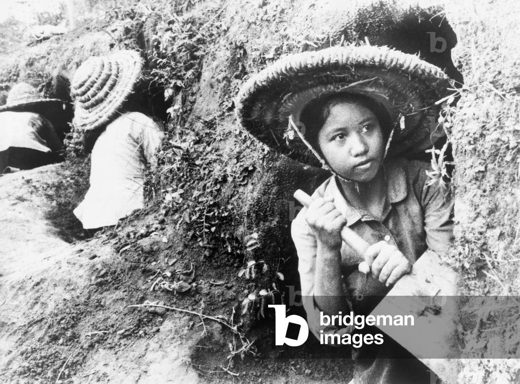 High school girls digging air raid shelters in a hillside in Hanoi, North Vietnam during the American bombings of 1965-1966