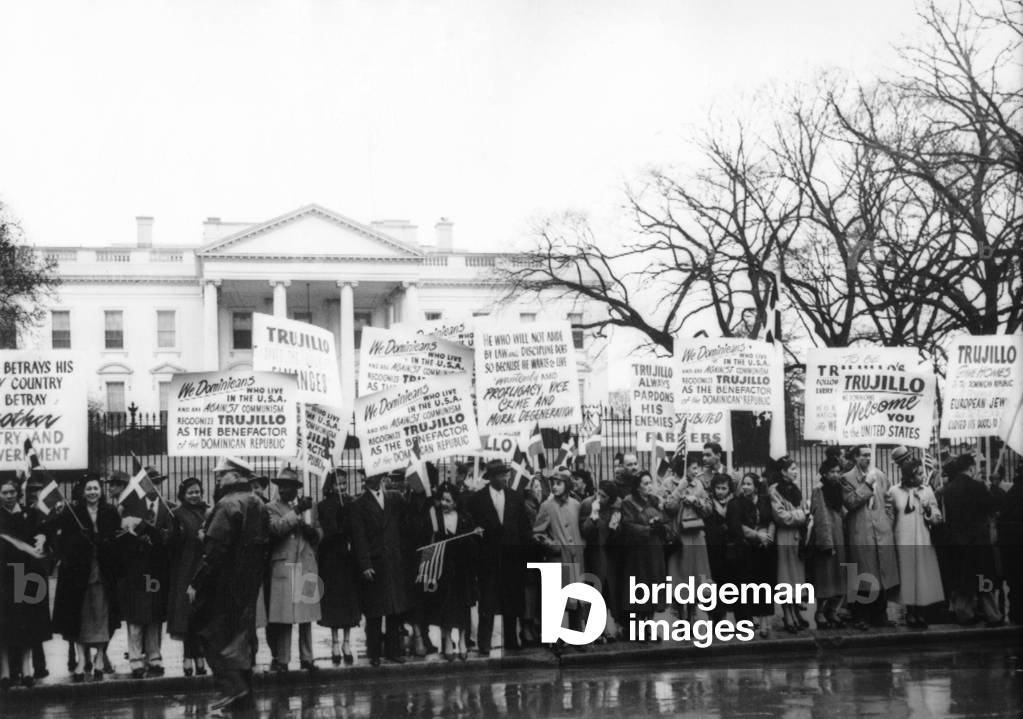 1000 Dominicans from New York City demonstrate loyalty to Generalissimo Rafael Trujillo. Signs welcome the dictator at the White House, Feb. 7, 1953. Trujillo, dictator of the Dominican Republic was on an extended trip to the U.S. in early 1953