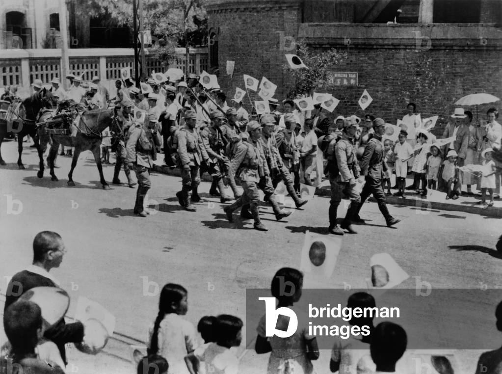 Japanese residents of Beijing, China, welcome Japanese invaders. Men, Women and children wave flags and shout 'Banzai' to invading Japanese troops, 1937