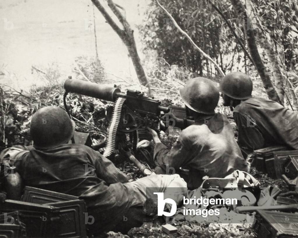 U.S. Army machine gun crew fires on Japanese positions on slopes of Mt. Tapotohan, on Saipan. c. June 15-July 9, 1944, during World War 2