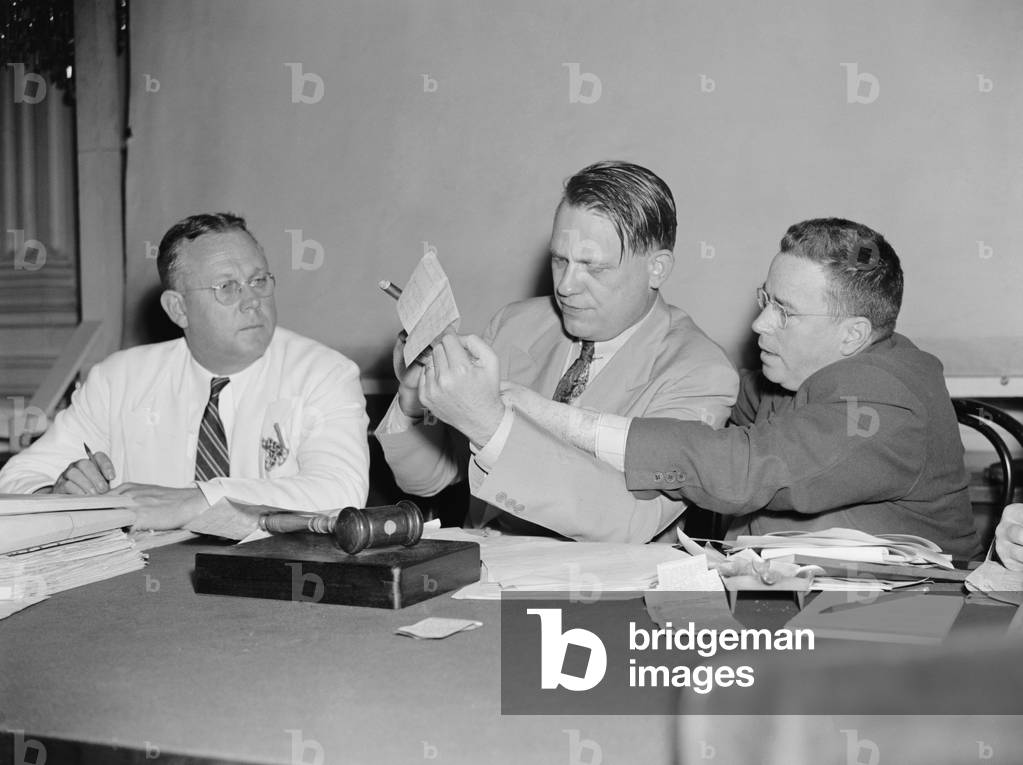 HUAC Chairman Martin Dies (center) views communist evidence, Aug. 1938. At right is investigator Edward F. Sullivan, who claimed to have uncovered 'red' activities in Hollywood