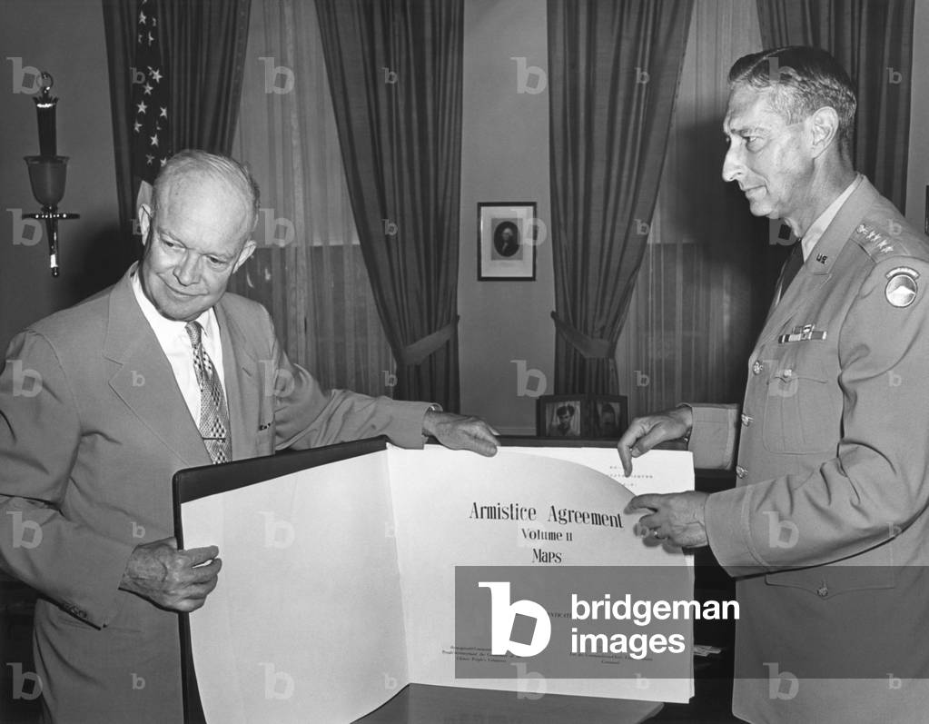 President Eisenhower with General Mark Clark displaying the Korean War Armistice Agreement. The bound volume of maps defined the Demilitarized Zone that divided North and South Korea. c. July-Aug. 1953.