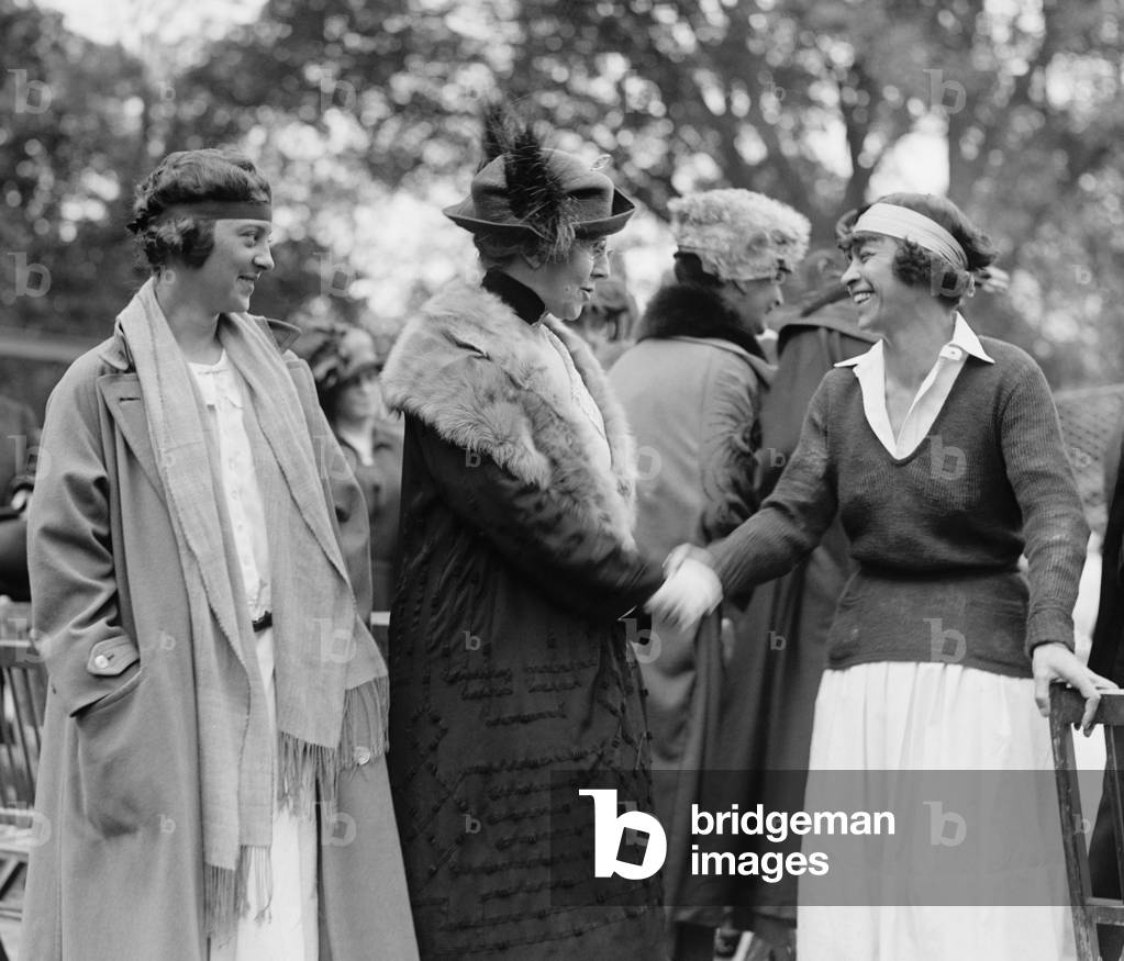 First Lady Florence Harding shaking hands with tennis champion, Molla Mallory. Marion Jessup looks on at the White House tennis court. May 10, 1922