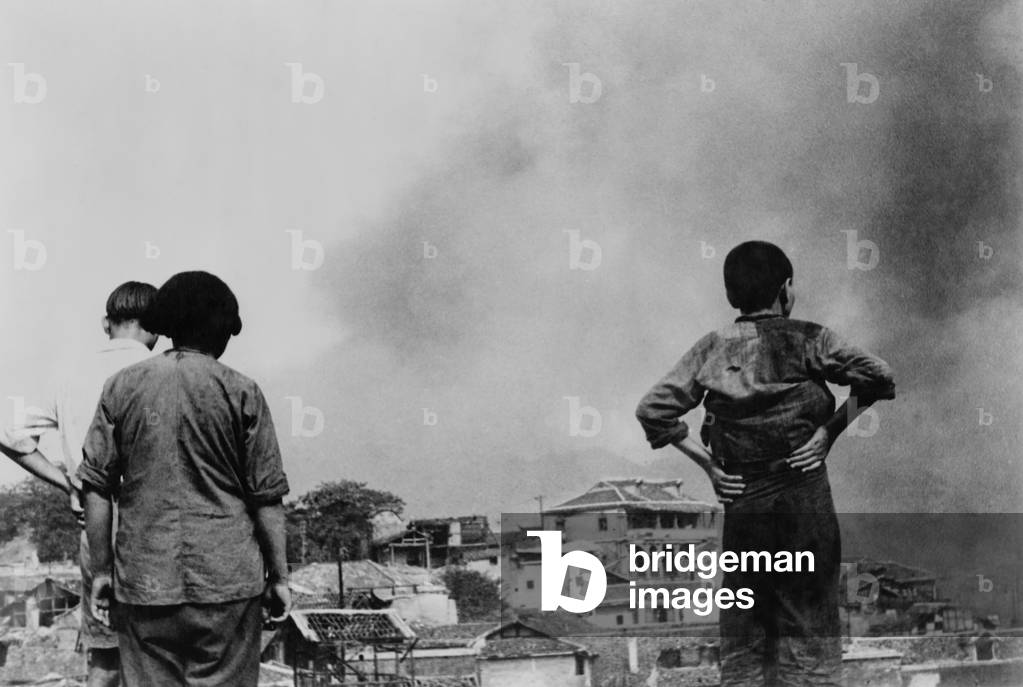 Three Chinese civilians in Chungking witness a Japanese air-raid. Second Sino-Japanese War/ World War 2. c.1937-45