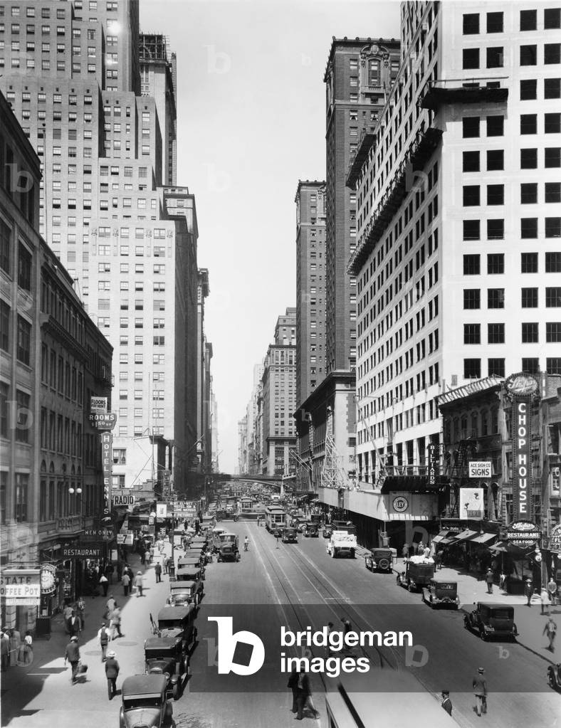 New York City's 42nd Street and Lexington Avenue, looking west. 1928-29. Chrysler Building on near right, with the Commodore Hotel behind it. Tall building in left mid-ground is the Chanin Building. c. 1929