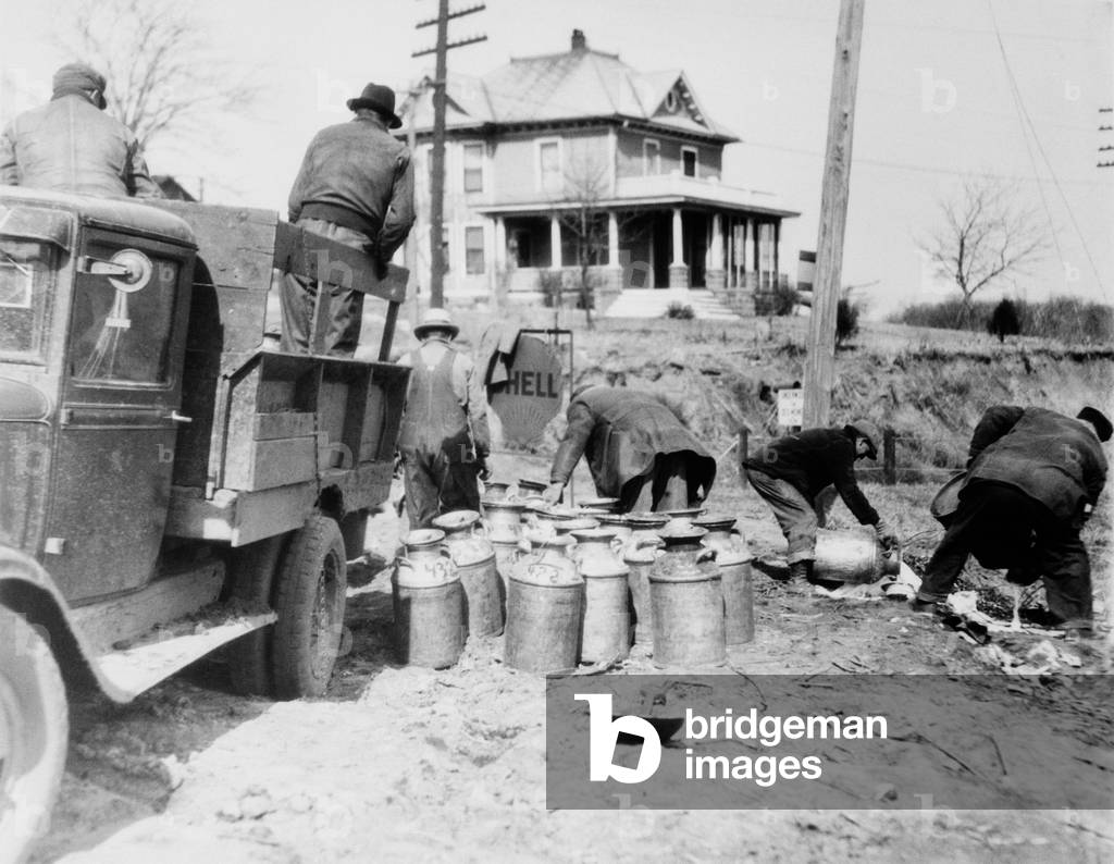 Striking farmers dump milk cans from a truck they have stopped to prevent delivery to market during the Great Depression. Milk strikes failed because most farmers were owner-operators and would not voluntarily destroy their produce. c. 1930-36