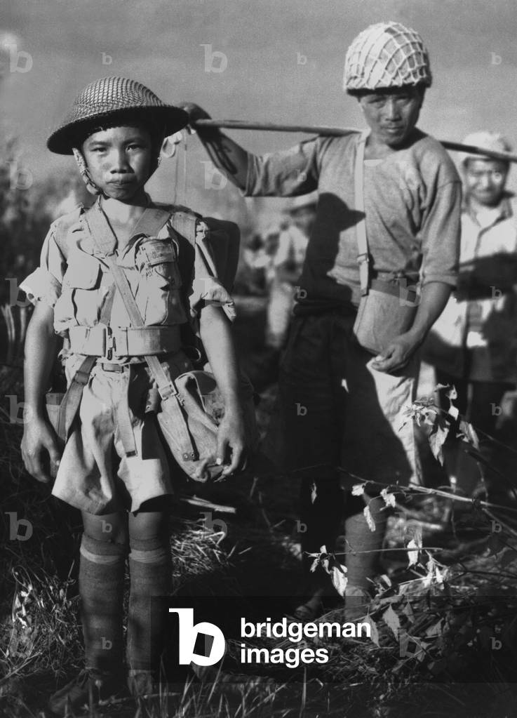 Chinese soldier, age 10, with heavy pack, is a member of a Chinese division. He is about to board a plane at Myitkyina, Burma, bound for China. Dec. 5, 1944. Second Sino-Japanese War/ World War 2