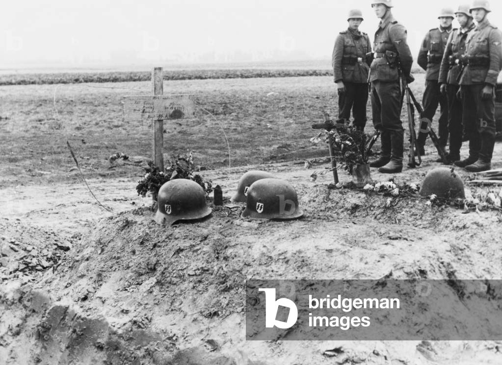 German Waffen-SS troops at the helmet topped graves of their fellows during the invasion of Poland. Sept. 1939. World War 2