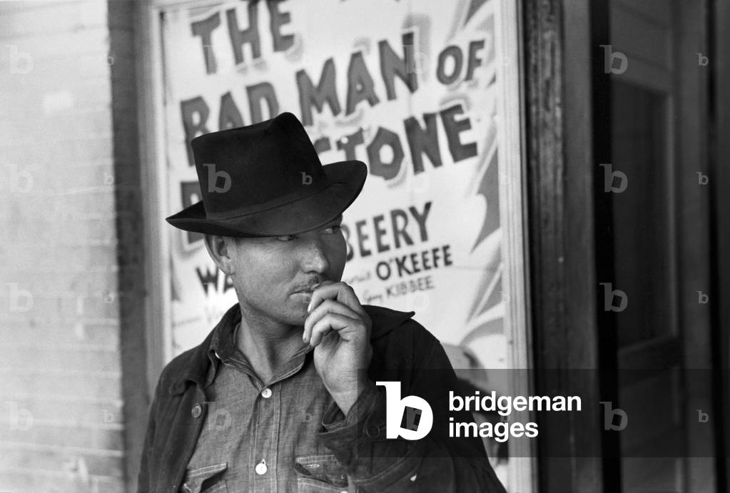 Man in front of a movie theater playing THE BAD MAN OF BRIMSTONE, Waco, Texas, photograph by Lee Russell, 1939.