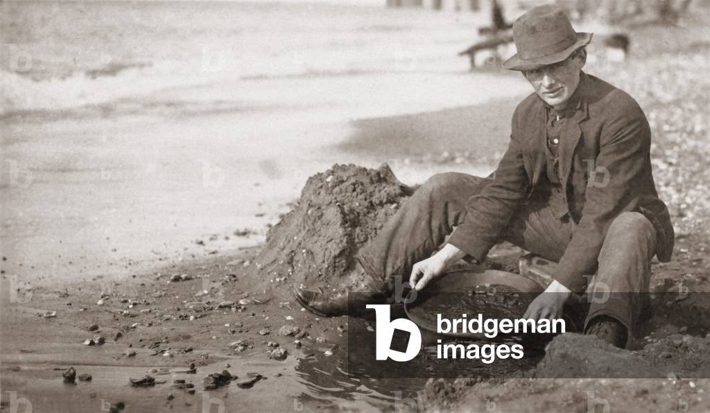 Man panning gold on Nome, Alaska, Beach in the early 20th century