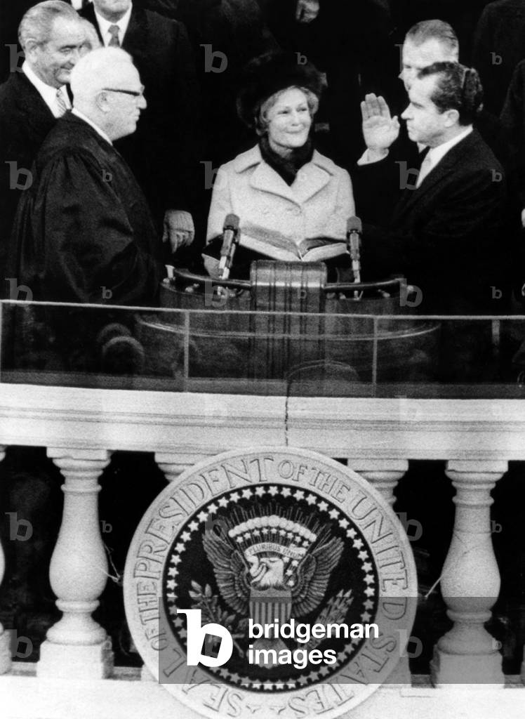 Chief Justice Earl Warren (left, with outgoing President Lyndon Johnson behind him), administering the oath of Richard Nixon (far right) as President, with Pat Nixon in the center, Washington D.C., January 20, 1969.