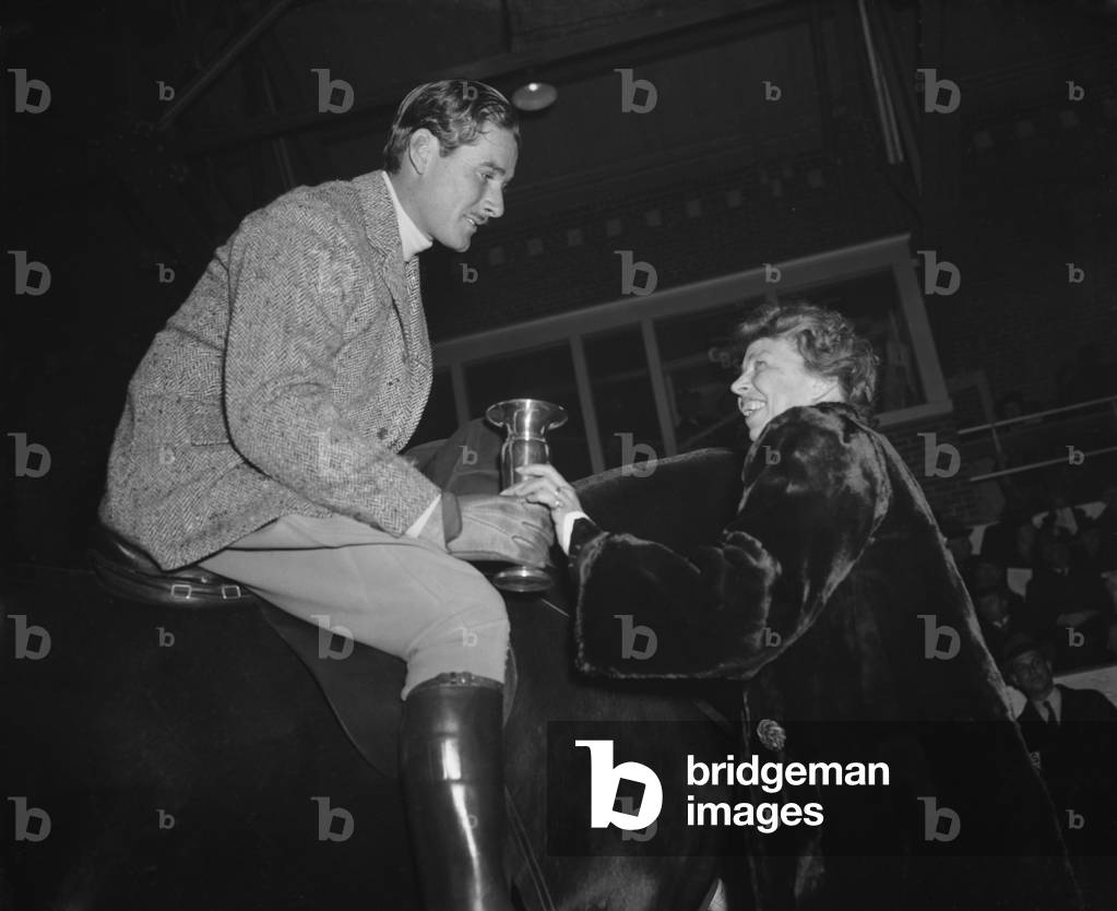 Eleanor Roosevelt presents a trophy to actor Errol Flynn, Jan. 1939. Flynn won the hack class trophy at the Fort Meyer President's Birthday Horse Show