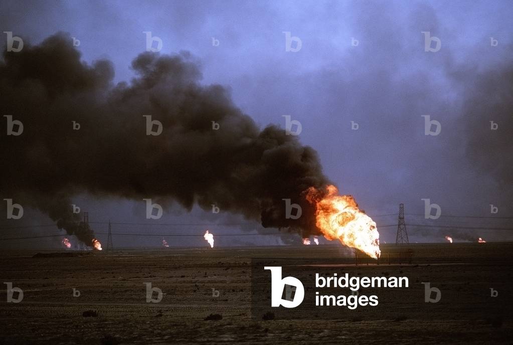 Kuwaiti oil wells set on fire by retreating Iraqi forces during Operation Desert Storm darken the sky with smoke. Mar. 1 1991