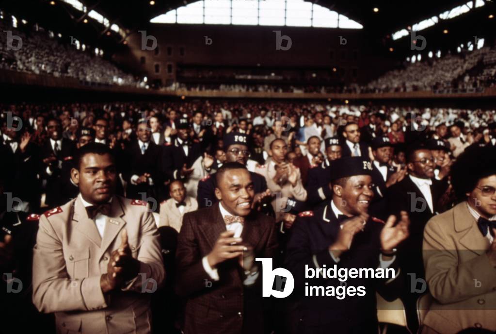 African American men applaud Black Muslim leader Elijah Muhammad during his Annual Savior's Day message in Chicago. March 1974