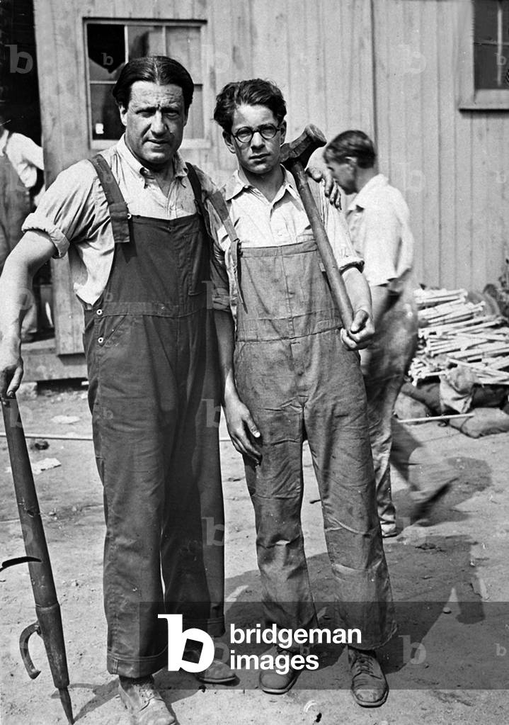 Dr. Stephen Samuel Wise, Rabbi of the Free Synagogue, became a laborer in the shipbuilding yards at Stanford, Conn., during World War I. Photo shows the famous religious leader with his eighteen year old son. July 1918