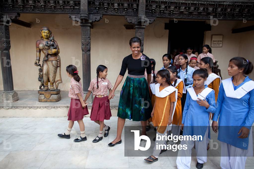 Michelle Obama accompanied by children from low income communities tours the National Craft Museum in New Delhi India. Michelle wears a skirt by Dries Can Voten and a pin by Alexis Bittar. Nov. 8 2010.,