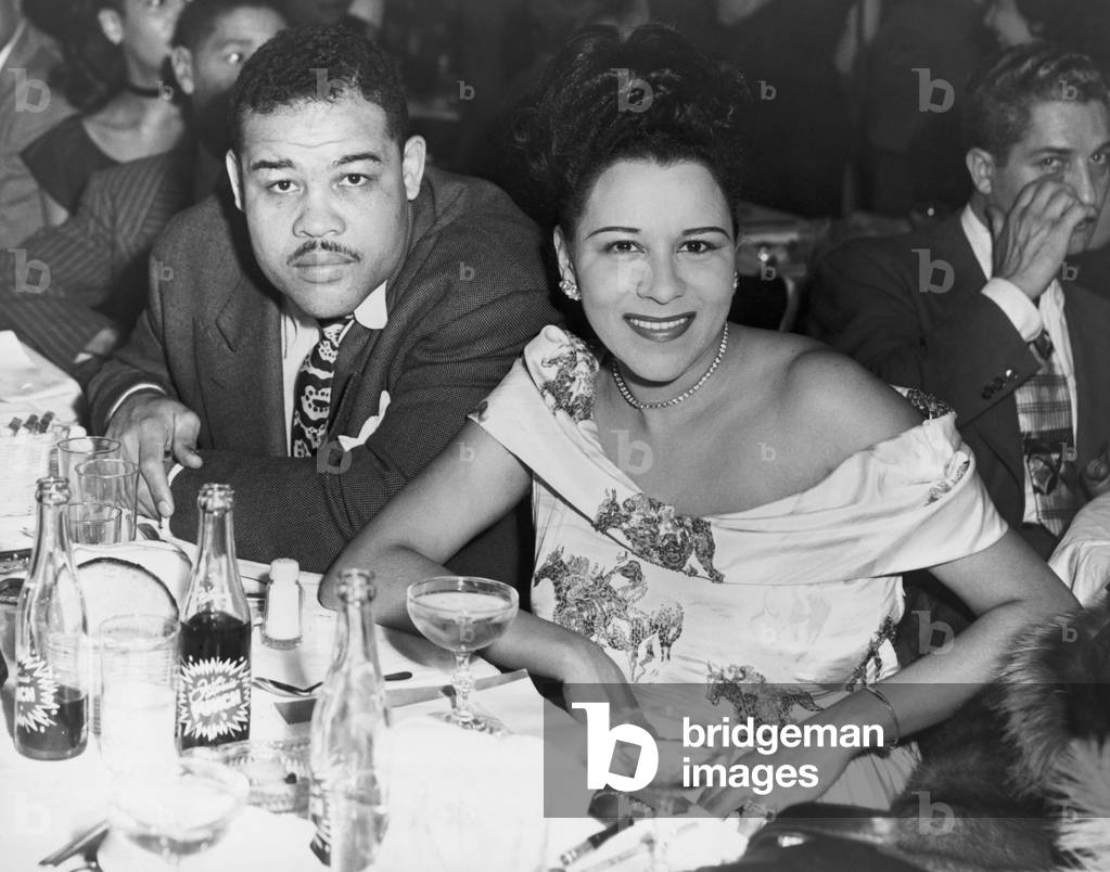 Heavyweight champ Joe Louis and his first wife Marva dining at a night club in 1947