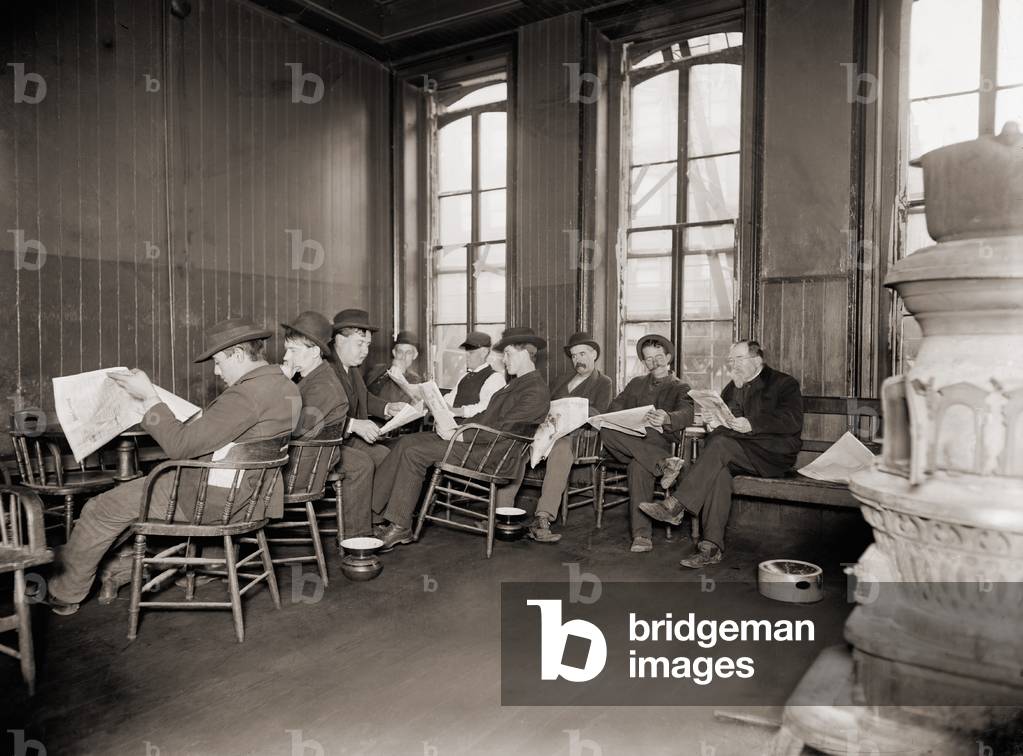 Homeless men in the reading room of a dime a night Bowery lodging house in 1910