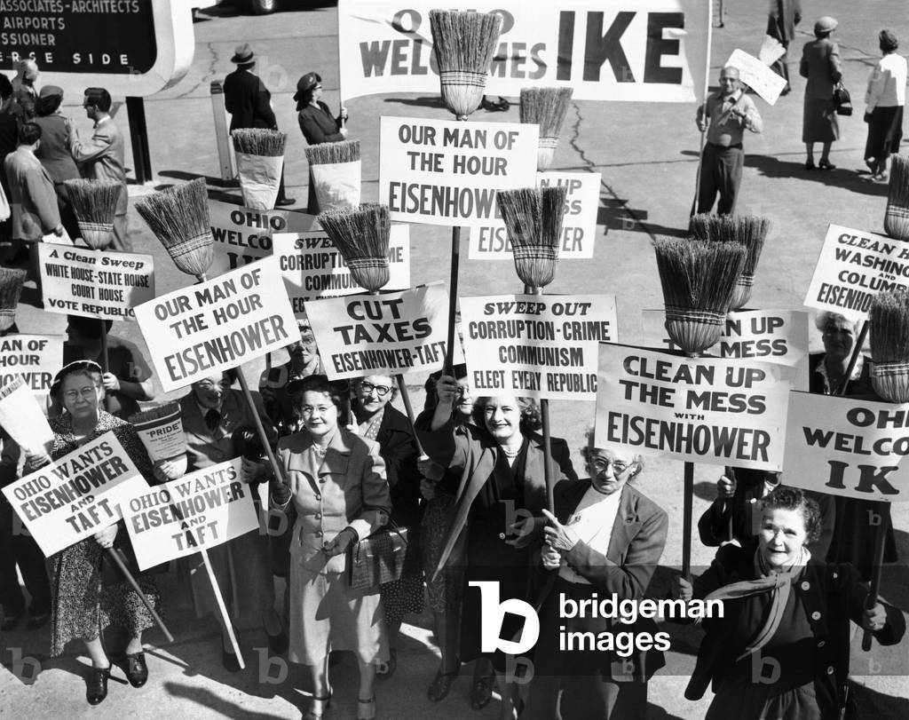 Pro-Eisenhower demonstrators with posters on household brooms, Sept. 8, 1952