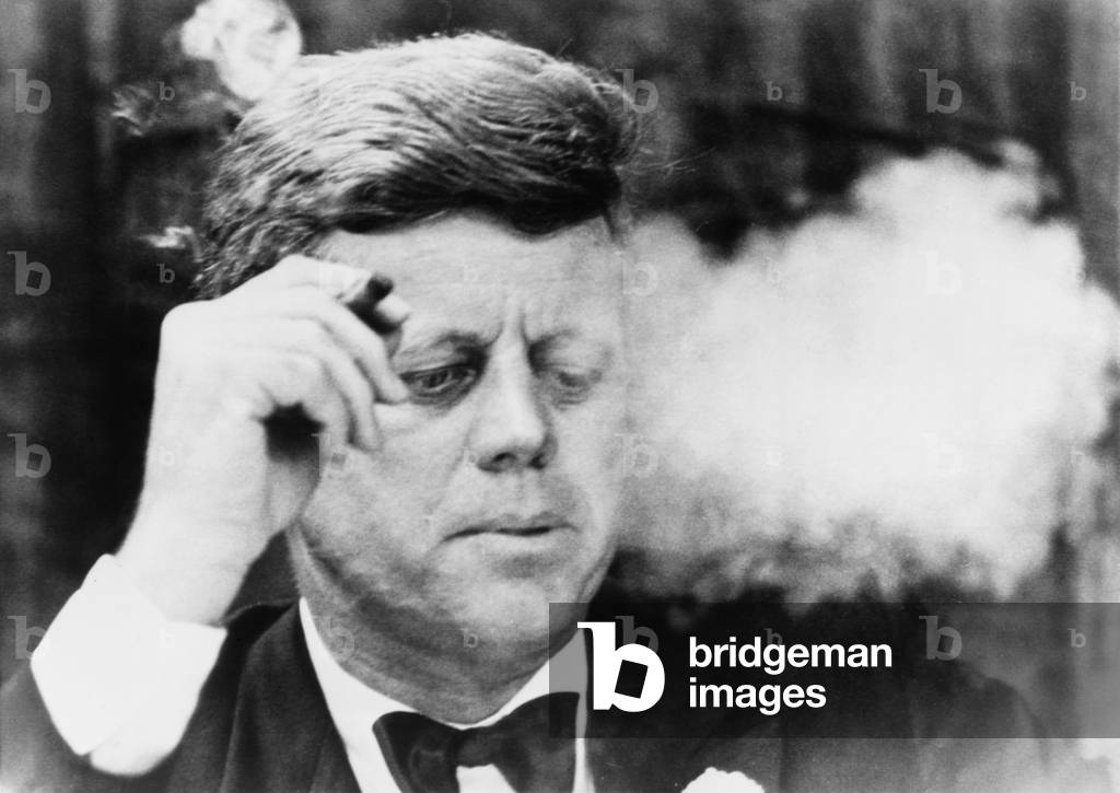 President John Kennedy, smoking a small cigar at a Democratic fundraiser in Boston's Commonwealth Armory. Oct. 19, 1963