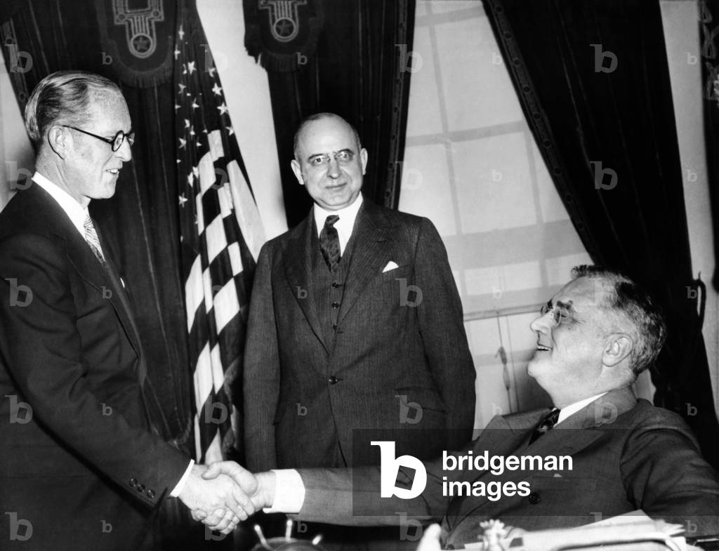 Joseph P. Kennedy takes the oath as U.S. Ambassador to the Court of St. James (Britain) with Supreme Court Justice STanley Reed in front of President Roosevelt. 2/18/1938