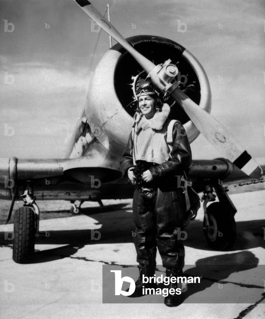Lt. Robert Taylor, USNR, standing beside a Navy trainer at a West Coast Naval Air Station, 1944. He was a flying instructor in Naval Air Corps, performed in instructional films, and narrated the documentary 'The Fighting Lady'