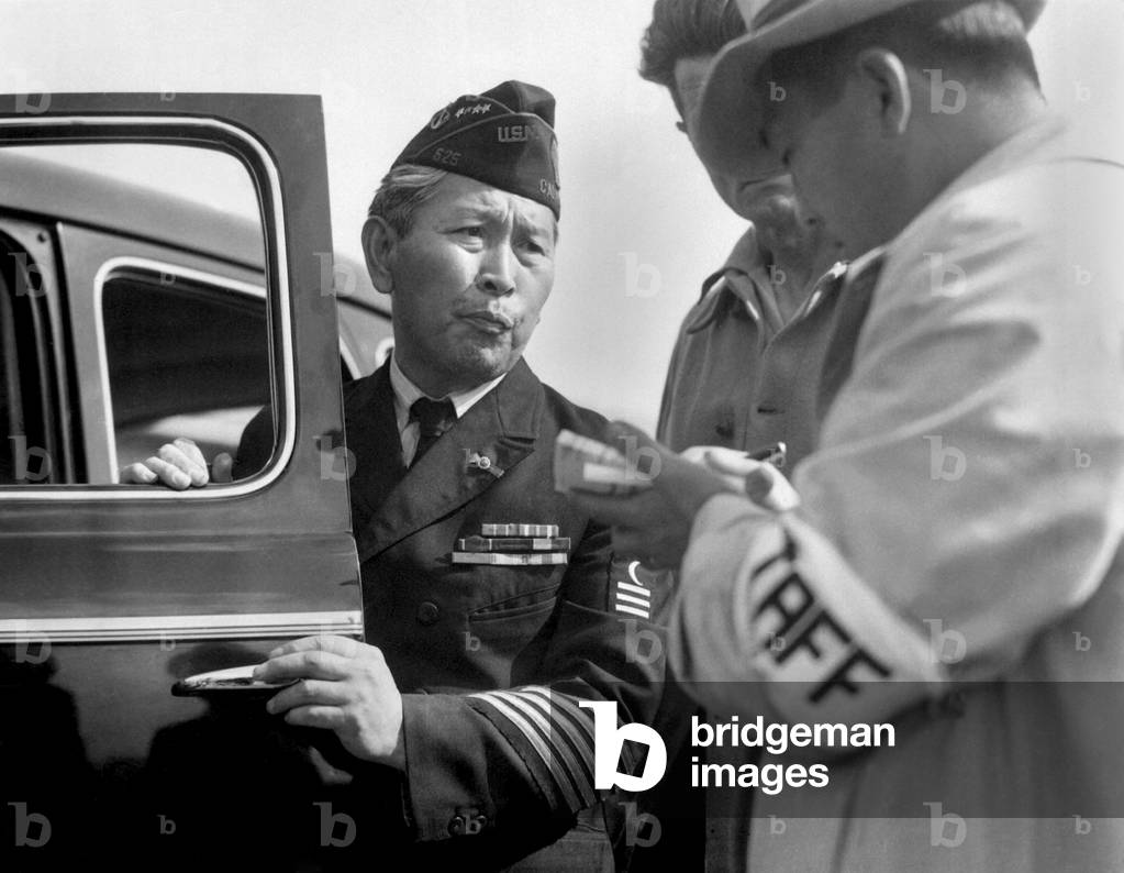 Dressed in uniform marking service in the First World War, this veteran enters Santa Anita assembly center for persons of Japanese ancestry evacuated from the West Coast, 1942 (b/w photo)